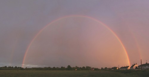 Dramatic reddened sunset rainbow